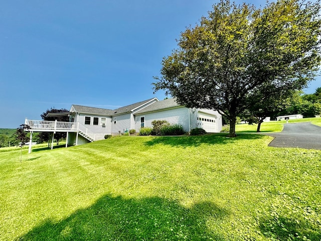 exterior space featuring a wooden deck and a lawn