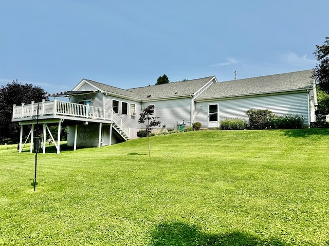 rear view of house with a yard and a wooden deck