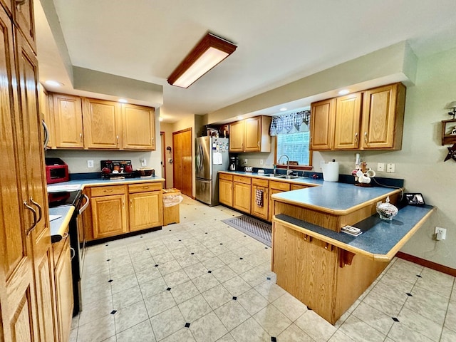 kitchen with sink, a breakfast bar area, light tile patterned floors, kitchen peninsula, and stainless steel appliances