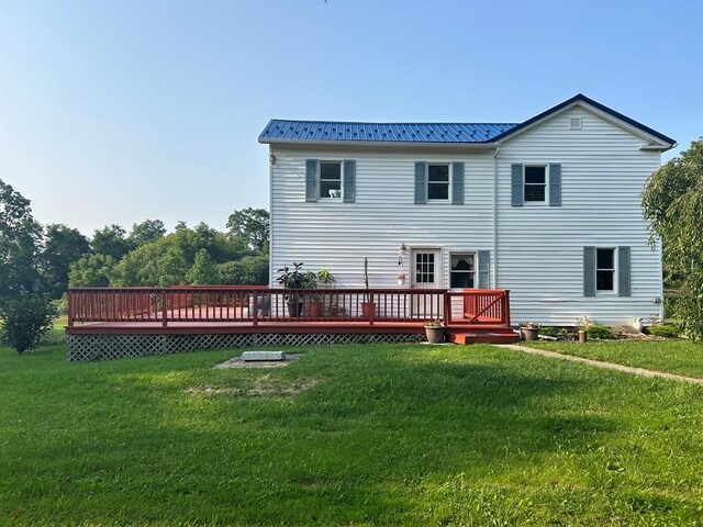 rear view of house with a deck and a yard