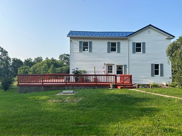 rear view of house featuring a deck and a lawn