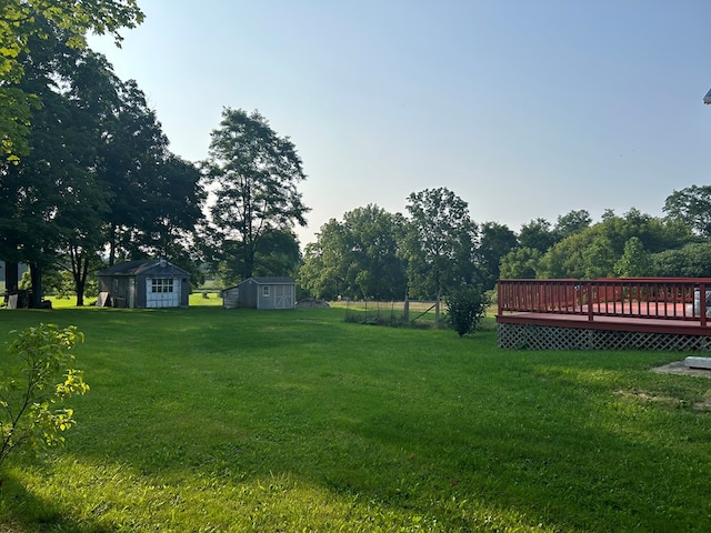 view of yard with a wooden deck and a storage unit