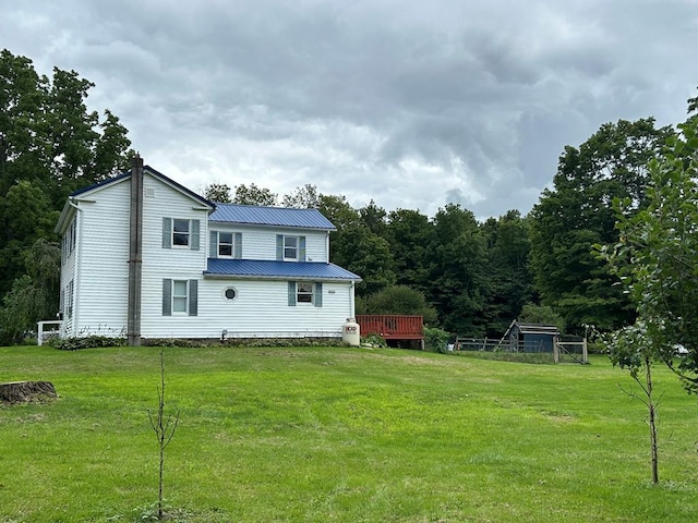 back of house featuring a wooden deck and a lawn