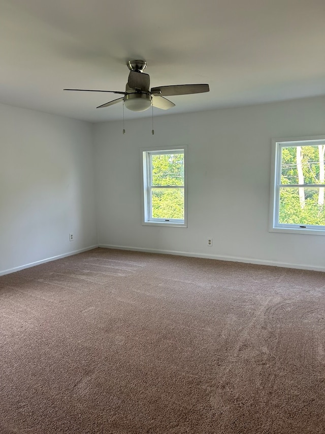 unfurnished room with ceiling fan and carpet