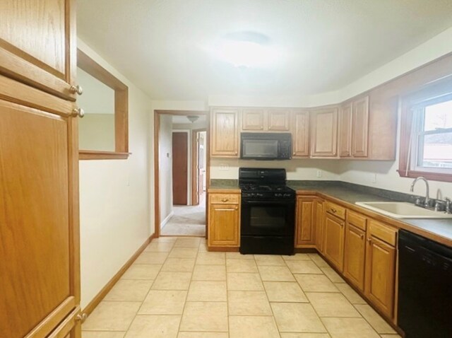 kitchen with light tile patterned flooring, sink, and black appliances