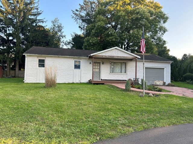 single story home featuring a garage and a front lawn