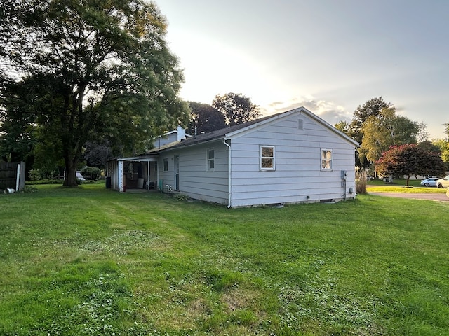 property exterior at dusk with a lawn