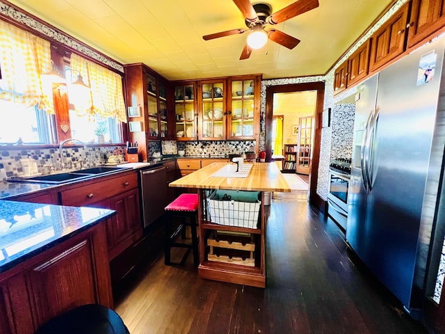 kitchen with dark hardwood / wood-style flooring, butcher block counters, sink, tasteful backsplash, and appliances with stainless steel finishes