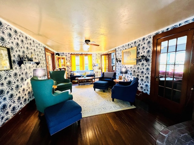 living room featuring ceiling fan, a textured ceiling, and hardwood / wood-style floors