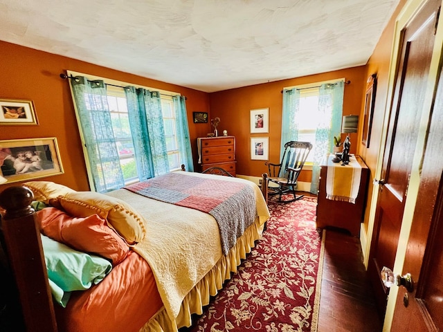 bedroom featuring dark hardwood / wood-style flooring and a textured ceiling