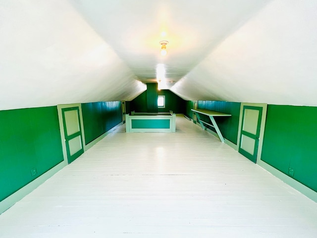 additional living space featuring hardwood / wood-style floors and vaulted ceiling