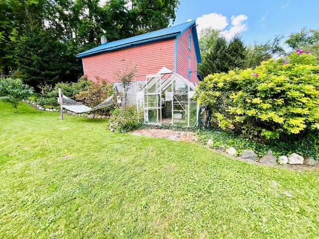 rear view of house with a yard and an outdoor structure