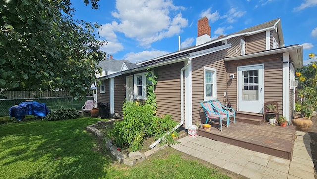 rear view of property with a lawn and a deck