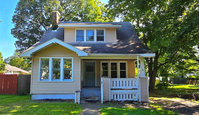 view of front of house with covered porch and a front yard