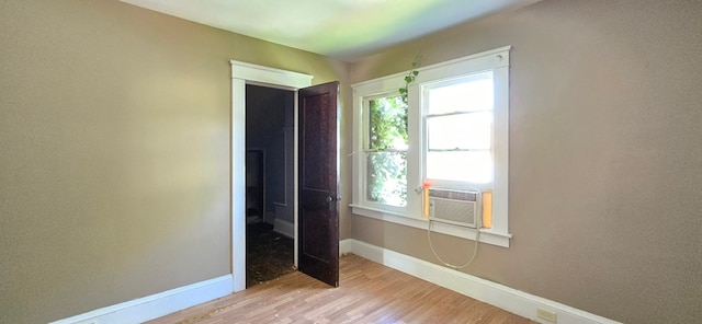 unfurnished bedroom featuring cooling unit and light wood-type flooring