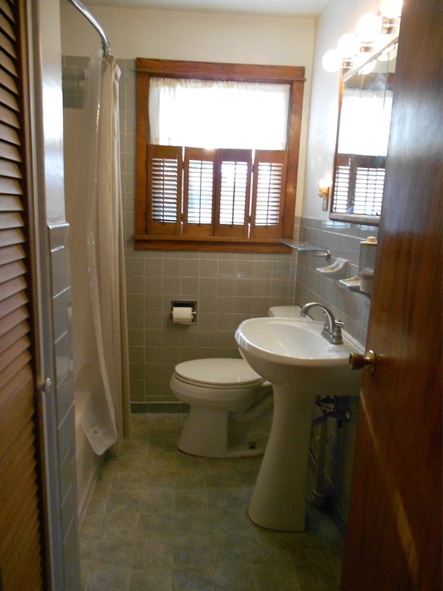 bathroom featuring tile walls, tile patterned floors, toilet, and walk in shower