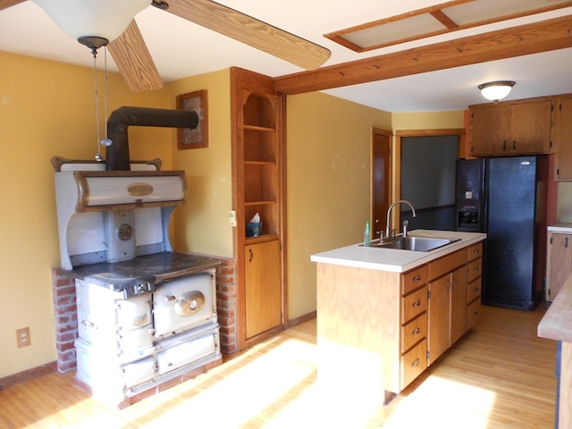 kitchen featuring light hardwood / wood-style flooring, sink, and black fridge