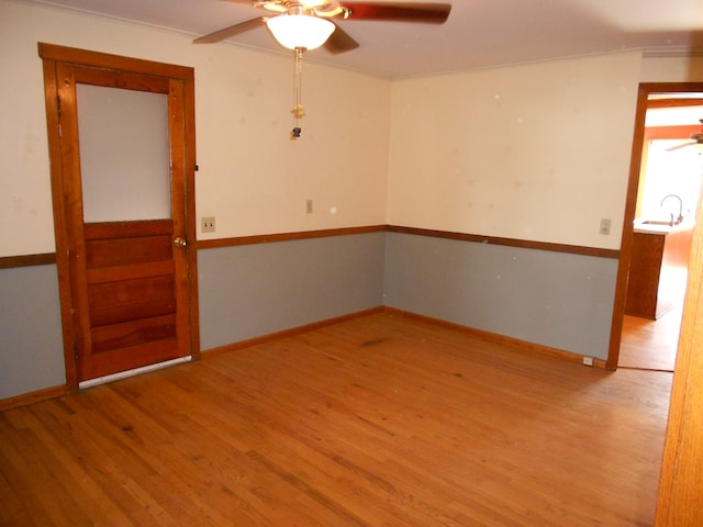 spare room with light hardwood / wood-style floors, ornamental molding, and ceiling fan