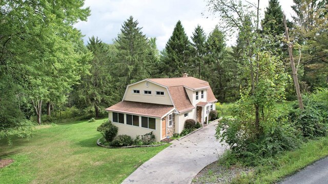 view of front of property featuring a sunroom and a front yard