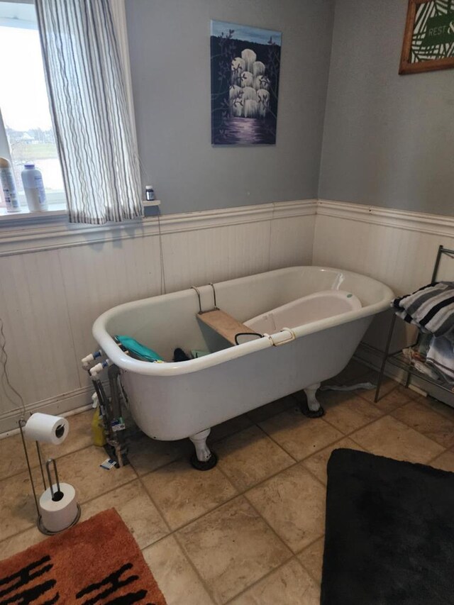 bathroom with a washtub and tile patterned flooring