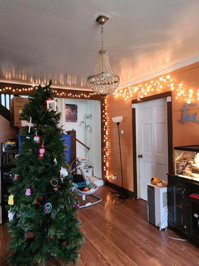 dining room with hardwood / wood-style flooring, crown molding, and a notable chandelier