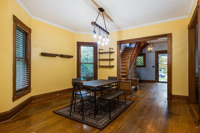 dining room featuring crown molding, dark hardwood / wood-style floors, and a wealth of natural light