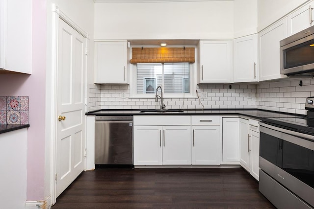 kitchen with stainless steel appliances, white cabinetry, sink, and backsplash