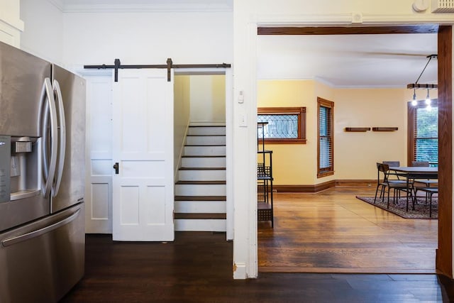 kitchen featuring crown molding, a barn door, hardwood / wood-style flooring, and stainless steel refrigerator with ice dispenser