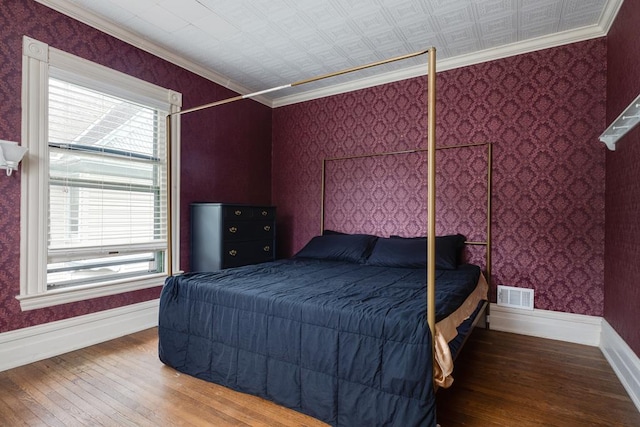 bedroom with crown molding and hardwood / wood-style flooring