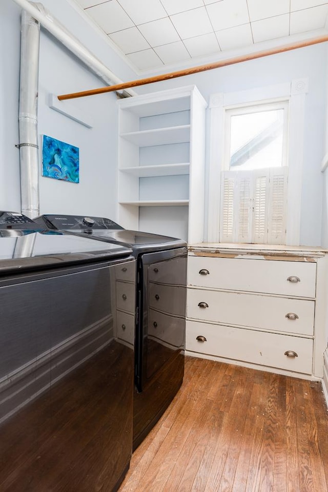 walk in closet with wood-type flooring and independent washer and dryer