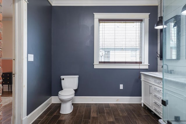 bathroom with crown molding, vanity, toilet, and a shower with door