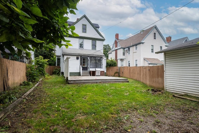 back of house with a wooden deck and a yard