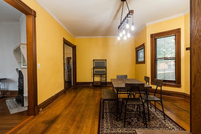 dining space featuring dark hardwood / wood-style flooring and crown molding