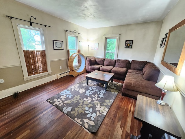 living room featuring a baseboard heating unit, a wealth of natural light, and dark hardwood / wood-style floors