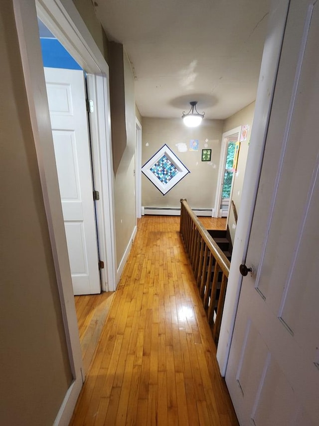 corridor featuring a baseboard radiator and light hardwood / wood-style floors