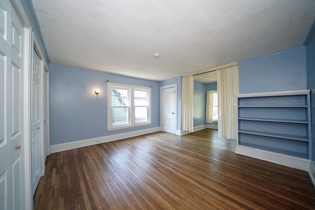 unfurnished living room featuring dark hardwood / wood-style flooring and a textured ceiling