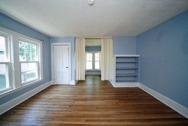 unfurnished bedroom featuring dark wood-type flooring and a textured ceiling