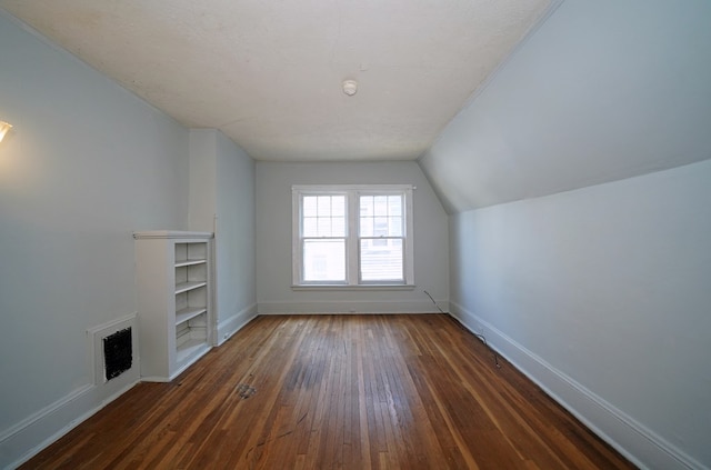 bonus room with dark hardwood / wood-style floors, a textured ceiling, and lofted ceiling