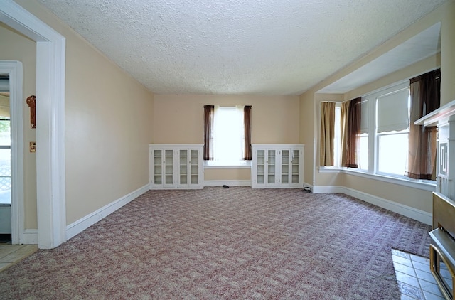 carpeted empty room with a wealth of natural light and a textured ceiling