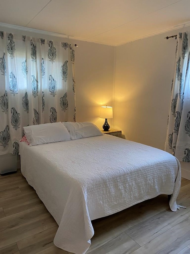 bedroom featuring crown molding and hardwood / wood-style flooring