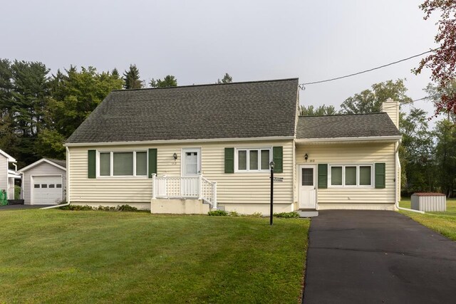 view of front of property featuring a garage, a front lawn, and an outdoor structure