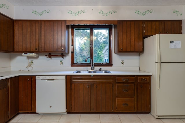 kitchen with sink, a textured ceiling, and white appliances