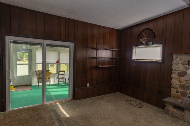 carpeted spare room with wood walls