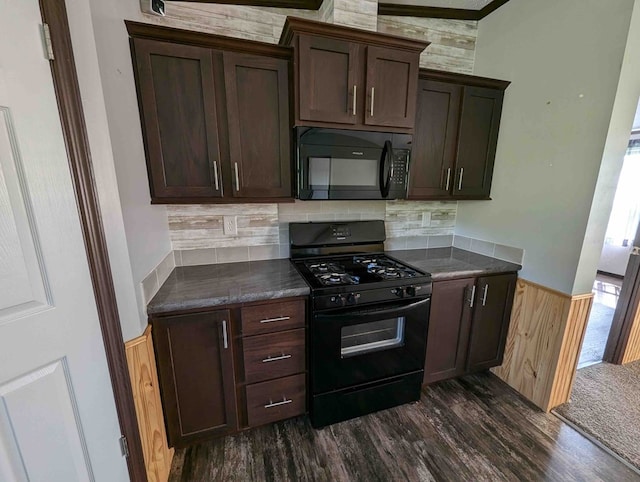 kitchen with backsplash, dark hardwood / wood-style floors, wood walls, and black appliances