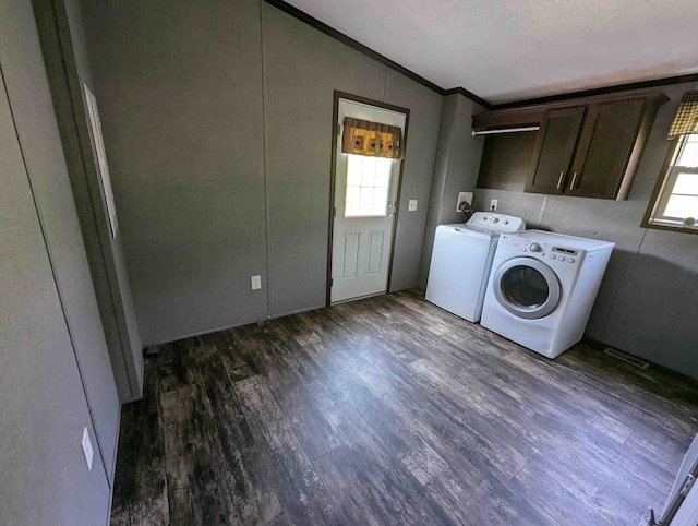 laundry room featuring cabinets, ornamental molding, dark wood-type flooring, and washing machine and clothes dryer