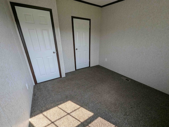 unfurnished bedroom featuring carpet and crown molding