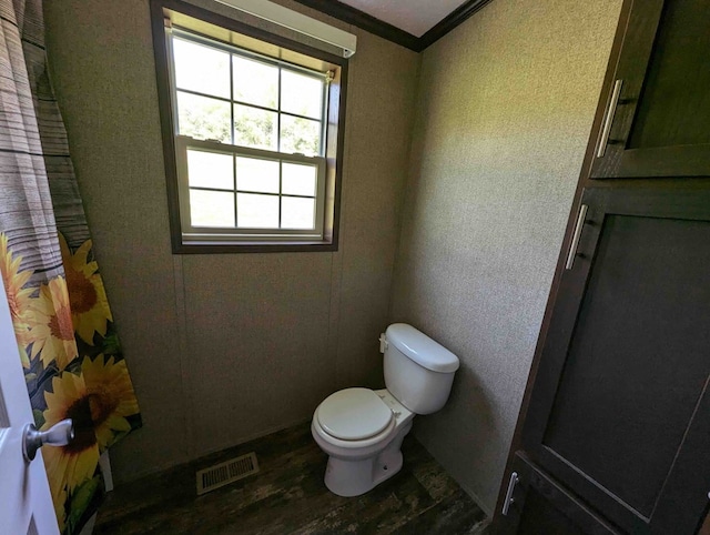 bathroom featuring hardwood / wood-style flooring, toilet, and ornamental molding