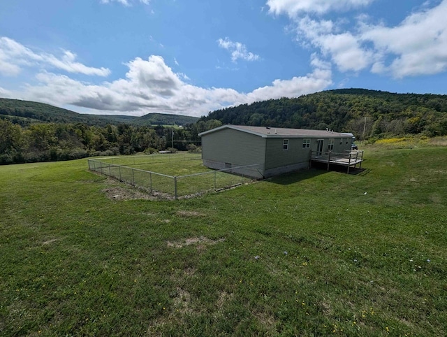 view of yard featuring a deck with mountain view and a rural view