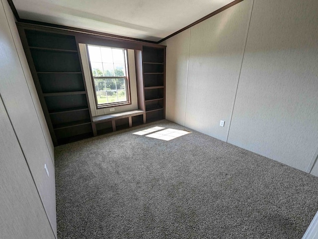 carpeted spare room featuring crown molding