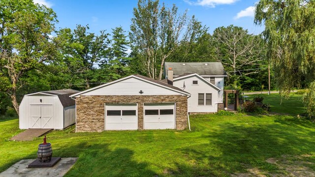 exterior space featuring a garage, a shed, and a front lawn